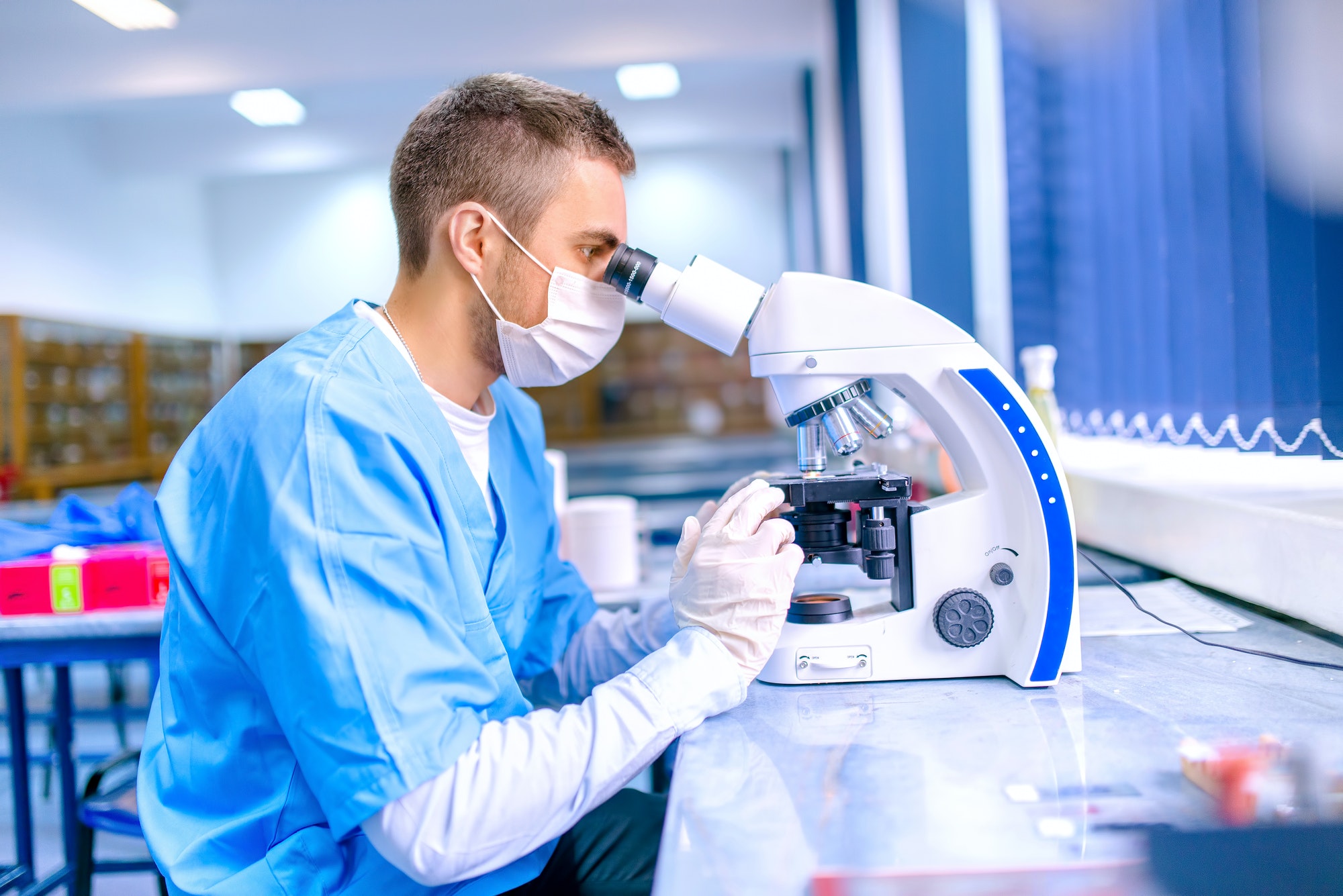 male-scientist-chemist-working-with-microscope-in-pharmaceutica.jpg
