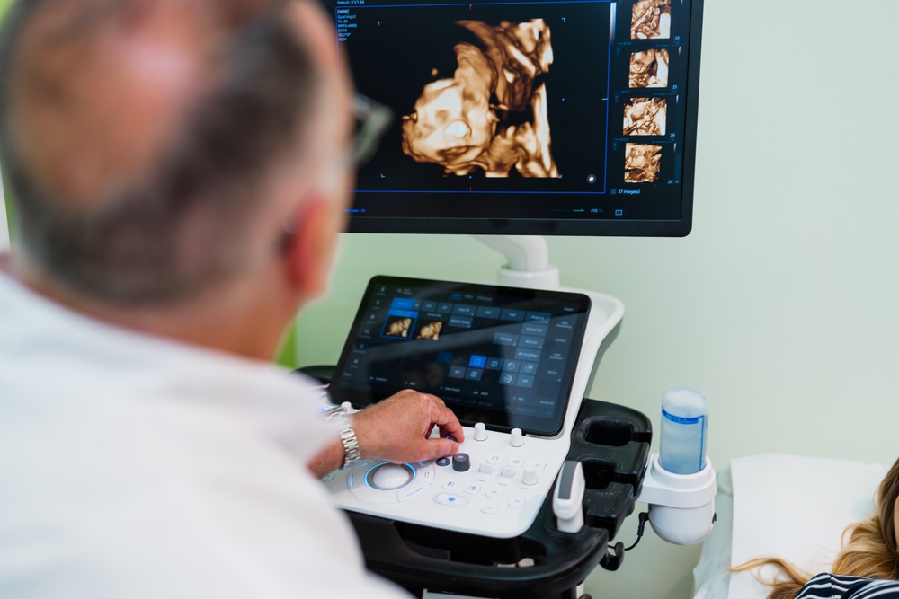 Gynecologist,Using,Modern,Ultrasound,Scanner,To,Examine,Pregnant,Woman,,Observing